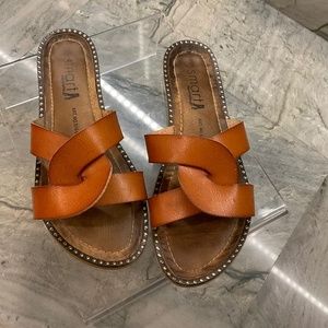 Smart shoe and fashion sandals crossed in front .